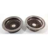 A pair of silver plated and turned wood bottle coasters