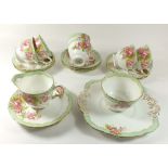 A 1930's Delphine 'Orchard' tea service comprising: six cups and saucers, six tea plates, cake