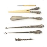 A set of three silver handled toiletry items including button hook, glove stretchers and shoe horn