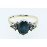 A 9 carat gold ring set blue stone flanked by six diamonds, size L to M