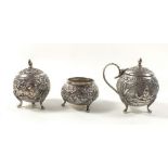 An Indian white metal three piece cruet set with embossed decoration, 6cm tall, 124g