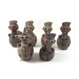 An unusual set of six terracotta nightlight holders in the form of tribal figures playing pipes