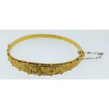 A Victorian 9 carat gold engraved and hinged bangle, boxed, 6g