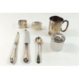A silver christening mug, silver spoon, two napkin rings and a cut glass silver topped dressing