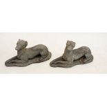 A pair of stone finish garden statues of recumbent greyhound dogs, 60cm long