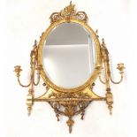 An 18th century Adam style oval girandole mirror with urn surmount, the glass flanked by four candle