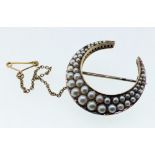 An Edwardian gold crescent form brooch set split pearls, 7.8g - unmarked but tested as gold, 2.7cm