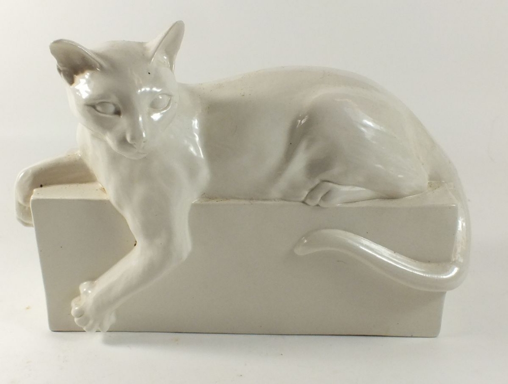 A white porcelain cat on plinth, 25cm across