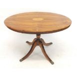 A Victorian mahogany oval table with marquetry inlay on turned column and reeded quadruple supports