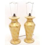 A pair of Indian lacquered yellow table lamps painted gilt swans, by Qasim Bros, 42cm tall