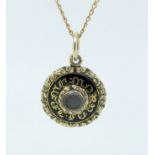 A Victorian gold and enamel circular mourning locket with inset hair panel on 9 carat gold chain,