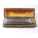 A Hohner harmonica cased