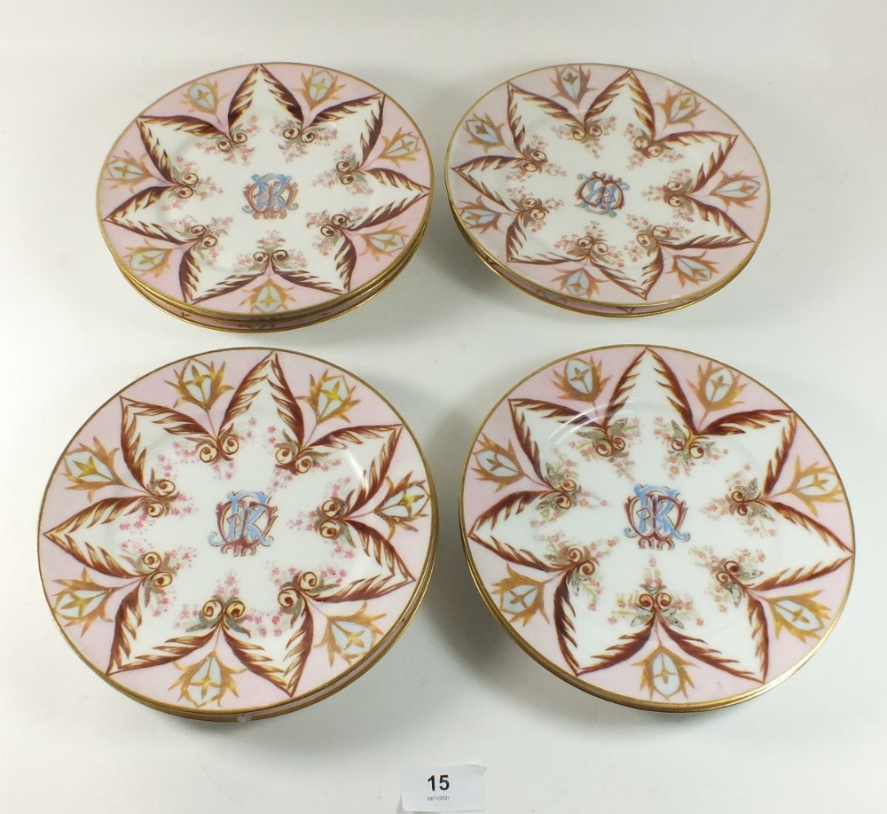A set of nine 19th century tea plates painted in pink and gilt with monogram to centre