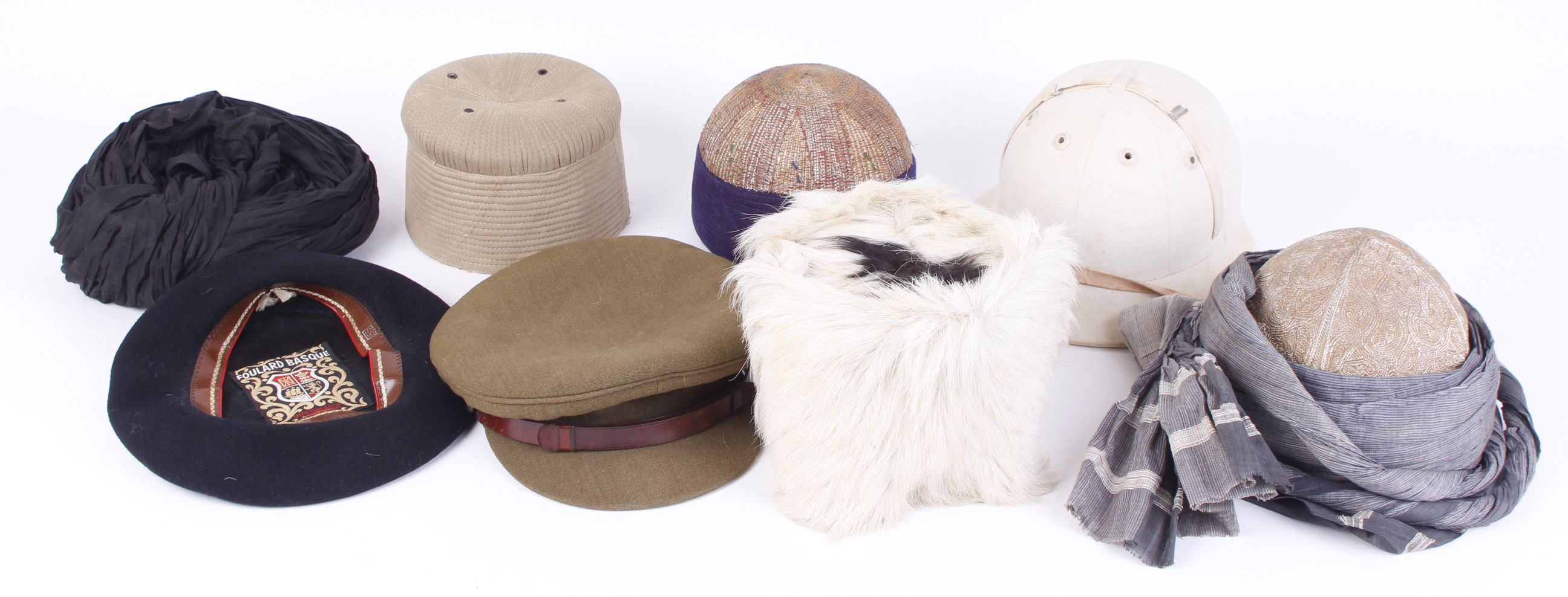 Two embroidered Indian skull caps and one other; Afhgan goat skin cap; British army field cap;