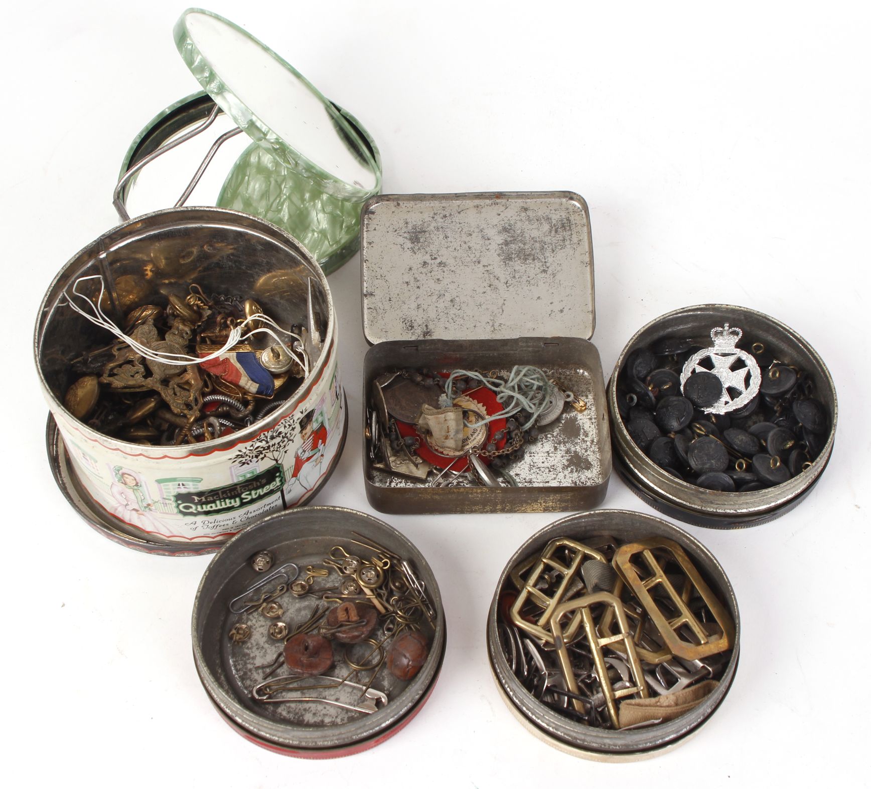 Five tins of miscellaneous military buttons; buckles; cap badges; epaulet rankings and travel mirror