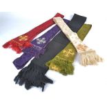 Five clerical stoles, four featuring stitched and beaded crosses and the ends bearing tassels,