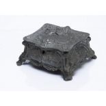 A continental pewter jewellery box, the cushion shaped box with hinged lid decorated with courting