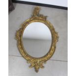 A 19th century oval wall mirror, with a gilded wooded gesso / plaster frame, 90cm x 140cm A/F
