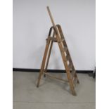 A vintage wooden hardwood folding step ladder, five steps plus platform, with a holding rail to