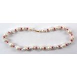 A baroque pearl and semi precious red stone necklace, length 21cm