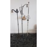 Three cast iron standard lamps, one with Art Deco painted shade, painted in white, now worn, on a