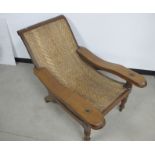 A 19th century teak Planters chair, rattan seat, working leg supports, raised on turned front