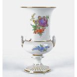 A late 19th Century Meissen twin handled campagna shaped urn with floral studies on a white