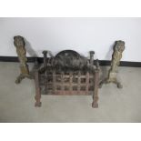 A cast iron fire grate, with a decorative back panel of a inn scene with seated figures, 40cm x 27cm