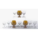 Three amber glass brandy glasses together with a quantity of Stuart crystal drinking glasses, the