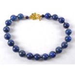 A lapis lazuli necklace with bulbous spherical hardstone beads, alternating with semi precious green