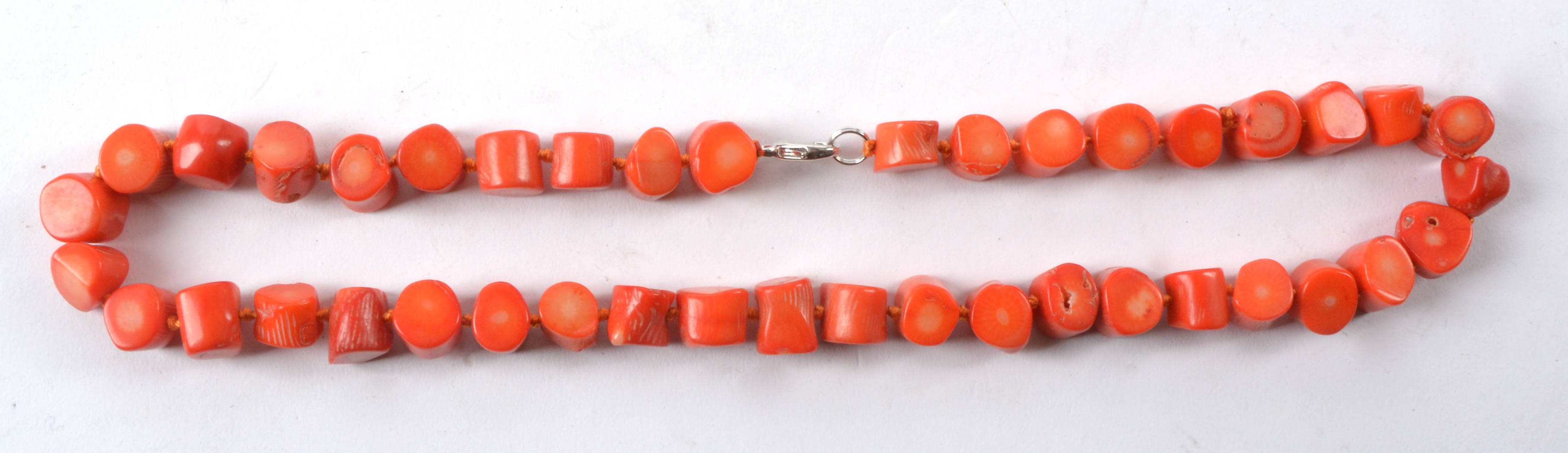 A polished coral necklace with near cylindrical beads, length 24cm