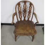An antique hoop back Windsor arm chair, elm seat, three pierced slates to back with a central target