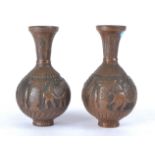 A pair of Middle Eastern copper vases with repousse work of figures attending upon a dignitary and