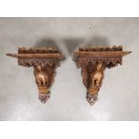 A pair of carved oak wall bracket shelves, with carved bird form. Each measuring 38cm x 30cm x 23cm.