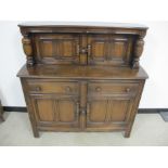 An Ercol style court cupboard, two door cupboard to top section above two frieze drawers with two