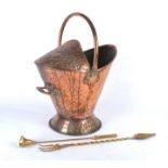 An Arts and Crafts copper coat bucket, with swing handle, above repousse decorated Art Nouveau