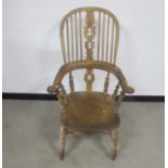 A 19th century elm hoop backed Windsor arm chair, pierced centre back splats, raised on turned
