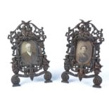 A pair of bronze effect mixed metal photograph frames with a surround of putti, 36cm x 23cm, one