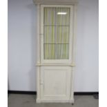An antique painted pine two section cabinet, top having a moulded cornice, four glazed panelled