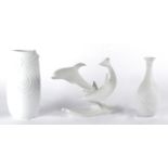 Three Kaiser Germany bisque white porcelain models, one depicting two dolphins swimming, signed '