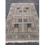 A Middle Eastern rug in blue tones with multiple rectangular panels of trees, and central