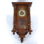 A early 20th Century mahogany cased wall clock, white enamel dial with Roman numerals, mounted on