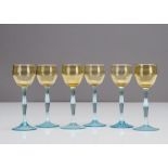 Six German Art Nouveau liquor glasses, the tulip shaped amber bowls supported on shaped blue stems