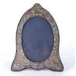 A silver mounted Elizabeth II frame of oval form surrounded by ornate scrolling decoration, London