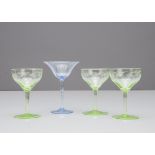 A set of three green engraved Art Nouveau liquor glasses, 10cm high together with a blue optic