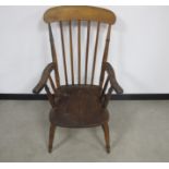 A 19th century beech and elm stick back arm chair, raised on turned supports