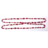 A necklace with semi precious red stones, some pebble lozenges and some multifaceted cuts, length