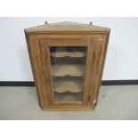 19th century waxed pine corner cupboard, glazed panelled door with three shaped fixed shelves to the