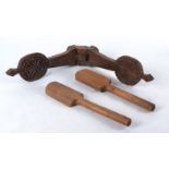 A piece of antique kitchenalia with two pieces of carved wood closing together to impress a