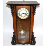 An ebonised cased Vienna style hanging wall clock, the enamel dial with Roman numerals, the pendulum